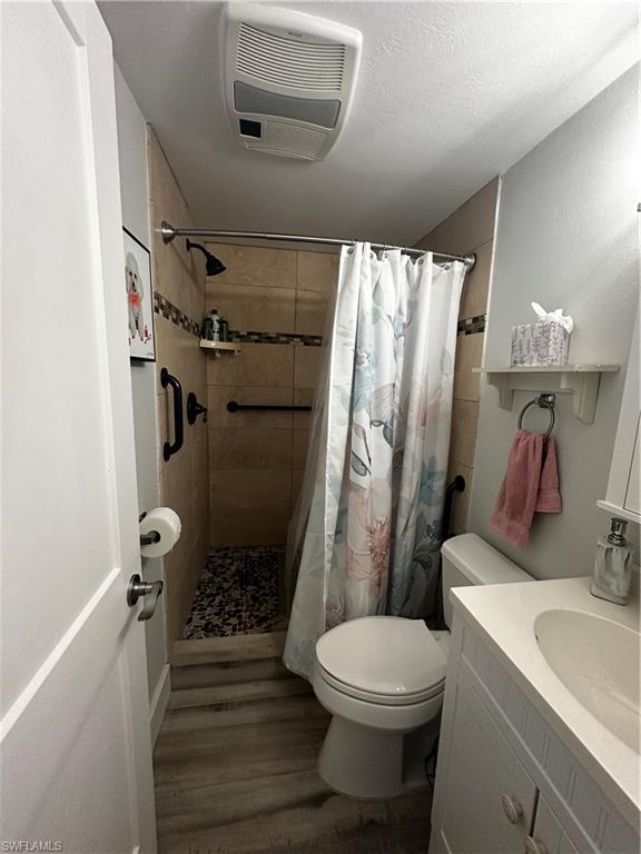 170 Pine Key Lane, Unit 13 Naples, FL 34114 - Photo 2 of 34 Bathroom featuring a shower stall, vanity, and dark wood-style flooring