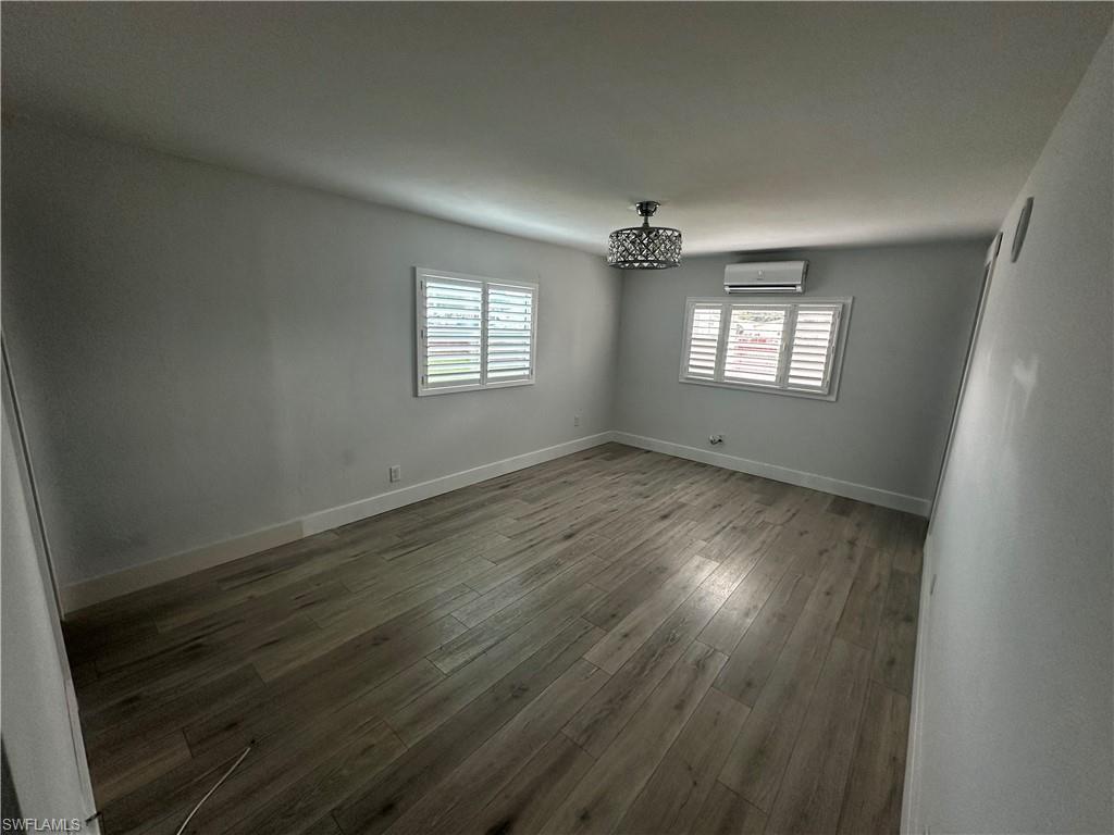 170 Pine Key Lane, Unit 13 Naples, FL 34114 - Photo 30 of 34 Unfurnished room with wood-type flooring and a mini split for heating / cooling
