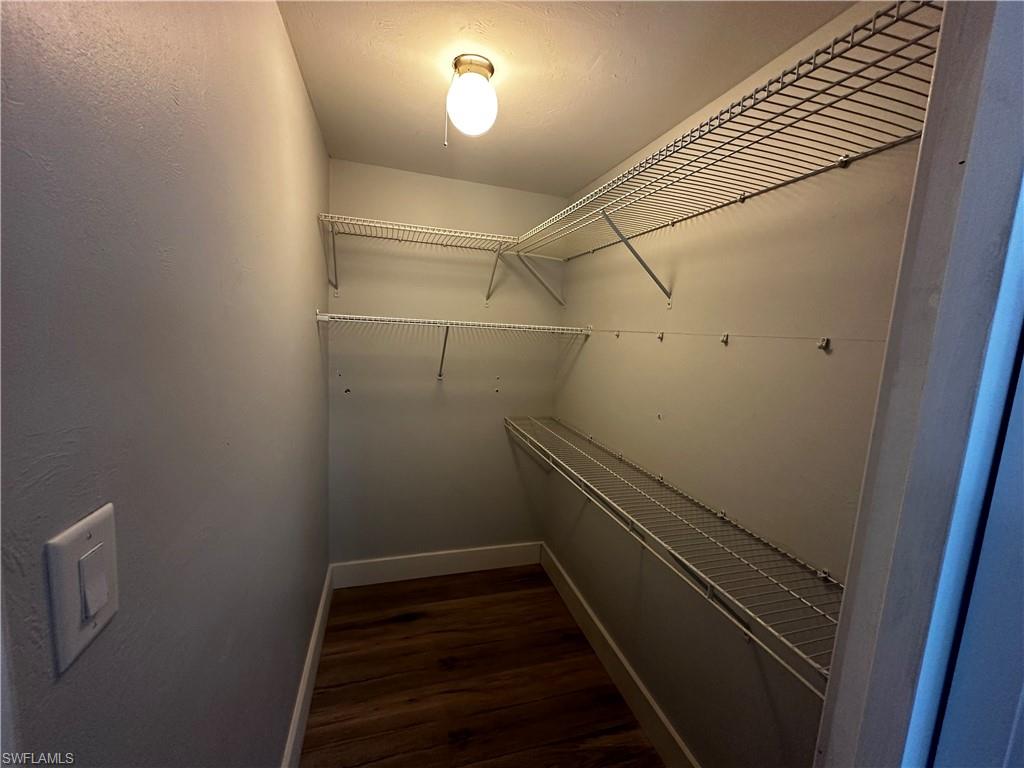 170 Pine Key Lane, Unit 13 Naples, FL 34114 - Photo 31 of 34 Walk in closet featuring dark wood finished floors