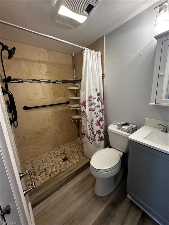 170 Pine Key Lane, Unit 13 Naples, FL 34114 - Photo 32 of 34 Full bath featuring vanity, a shower stall, and dark wood finished floors