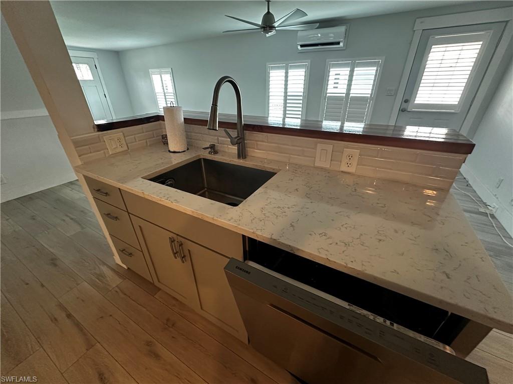 170 Pine Key Lane, Unit 13 Naples, FL 34114 - Photo 34 of 34 Kitchen with dishwasher, light wood-style floors, light stone countertops, and a ceiling fan