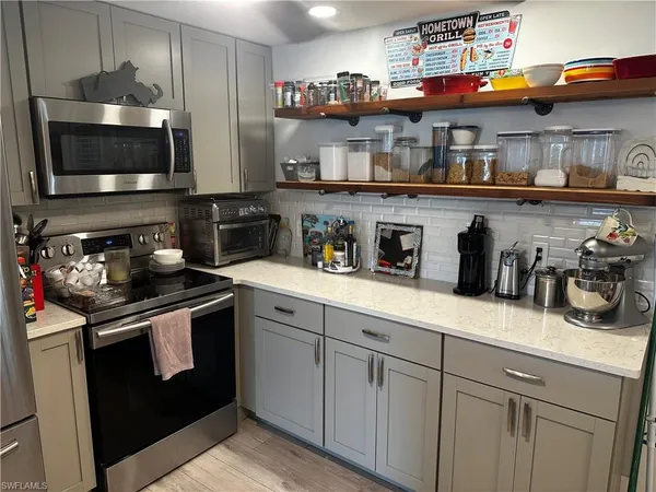 a kitchen with stainless steel appliances granite countertop a sink a stove and a wooden cabinets