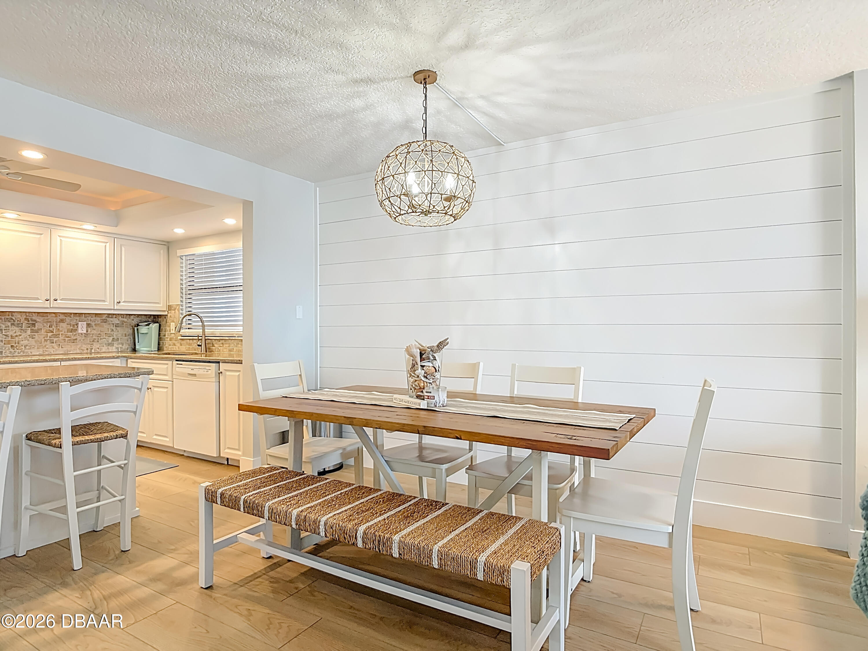 4445 South Atlantic Avenue, Unit 301 Ponce Inlet, FL 32127 - Photo 12 of 45 a view of a dining room with furniture a chandelier and kitchen view