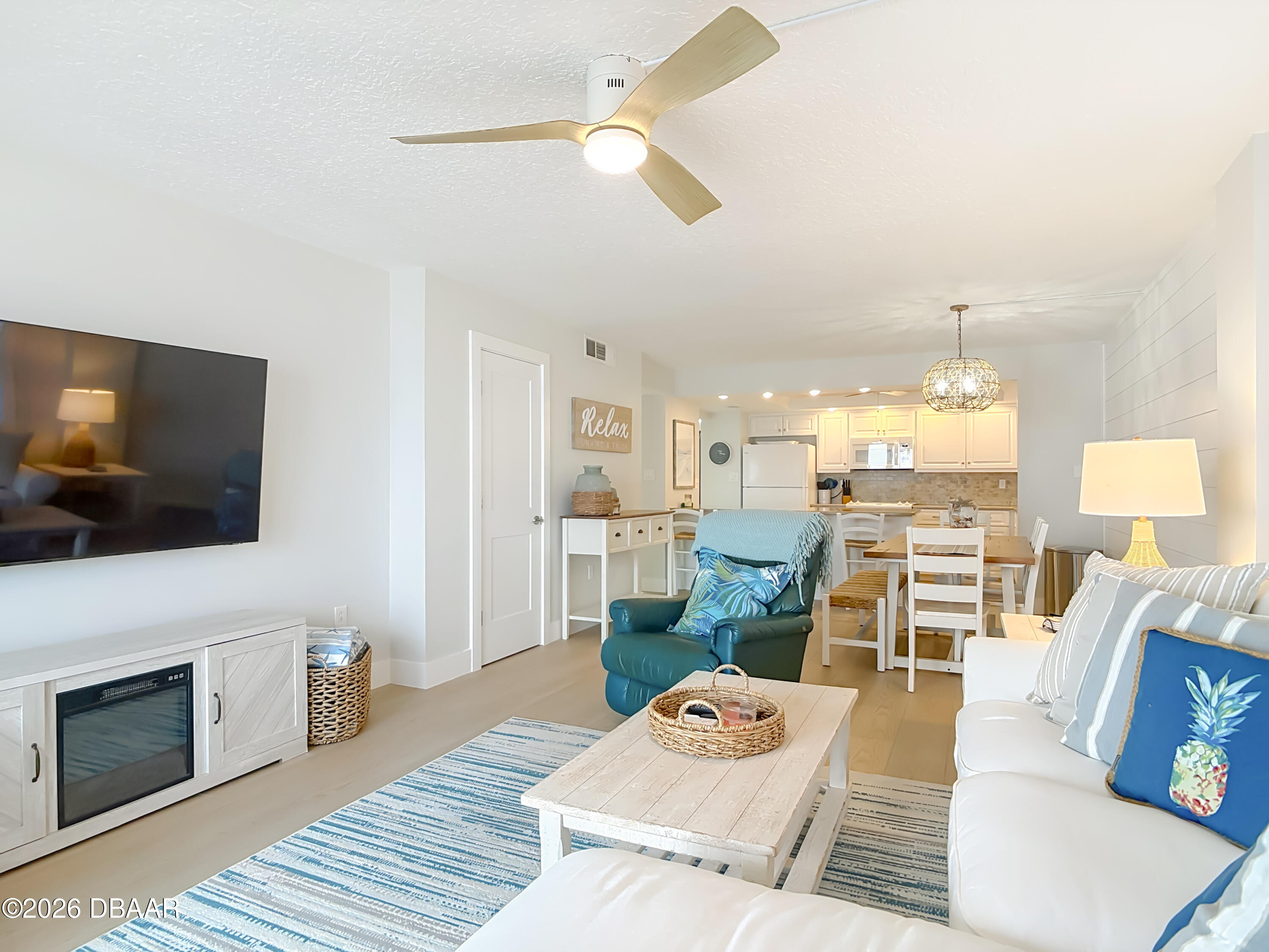 4445 South Atlantic Avenue, Unit 301 Ponce Inlet, FL 32127 - Photo 17 of 45 a living room with furniture a flat screen tv and a fireplace