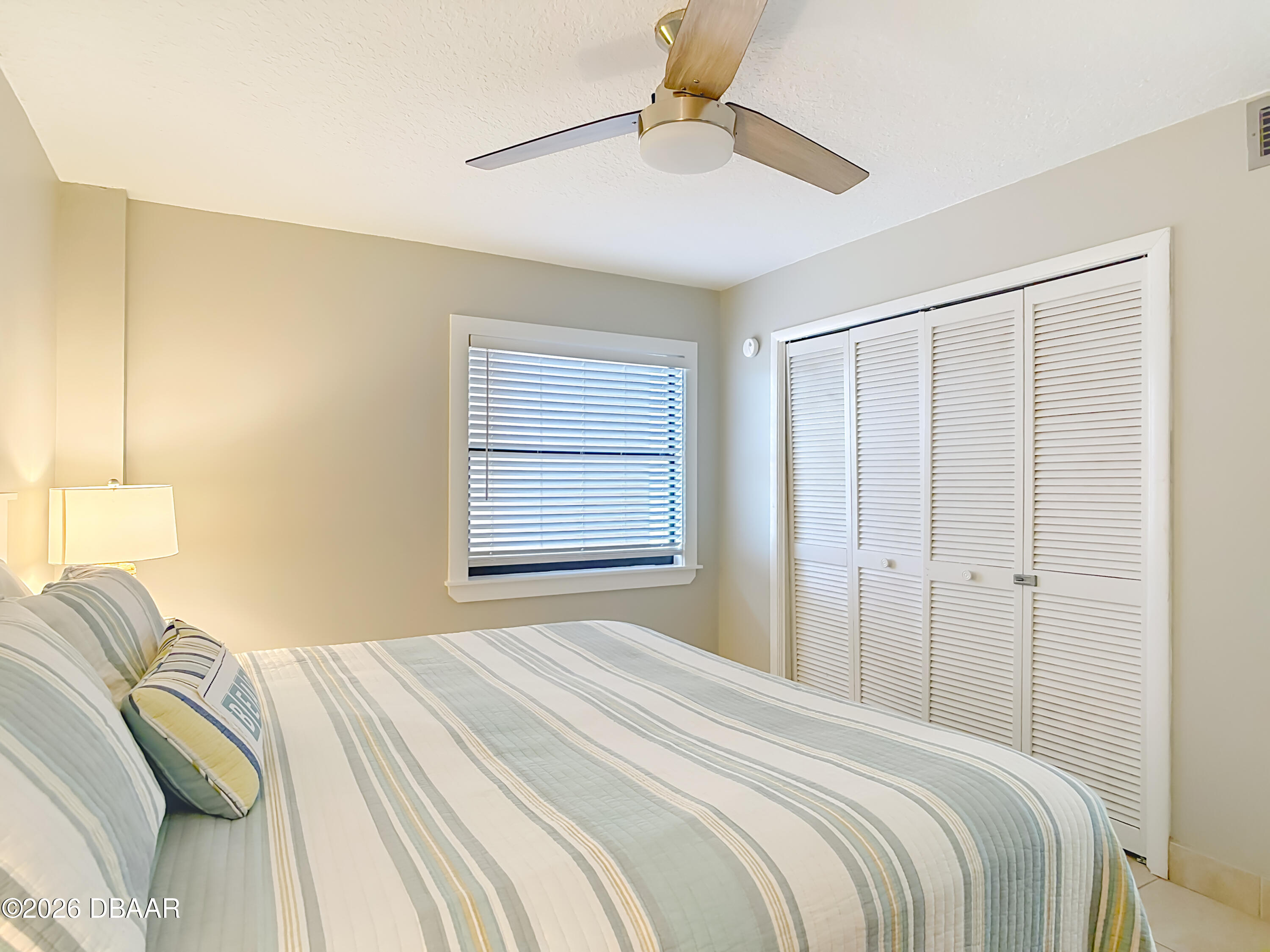 4445 South Atlantic Avenue, Unit 301 Ponce Inlet, FL 32127 - Photo 18 of 45 a bedroom with a bed and a chandelier