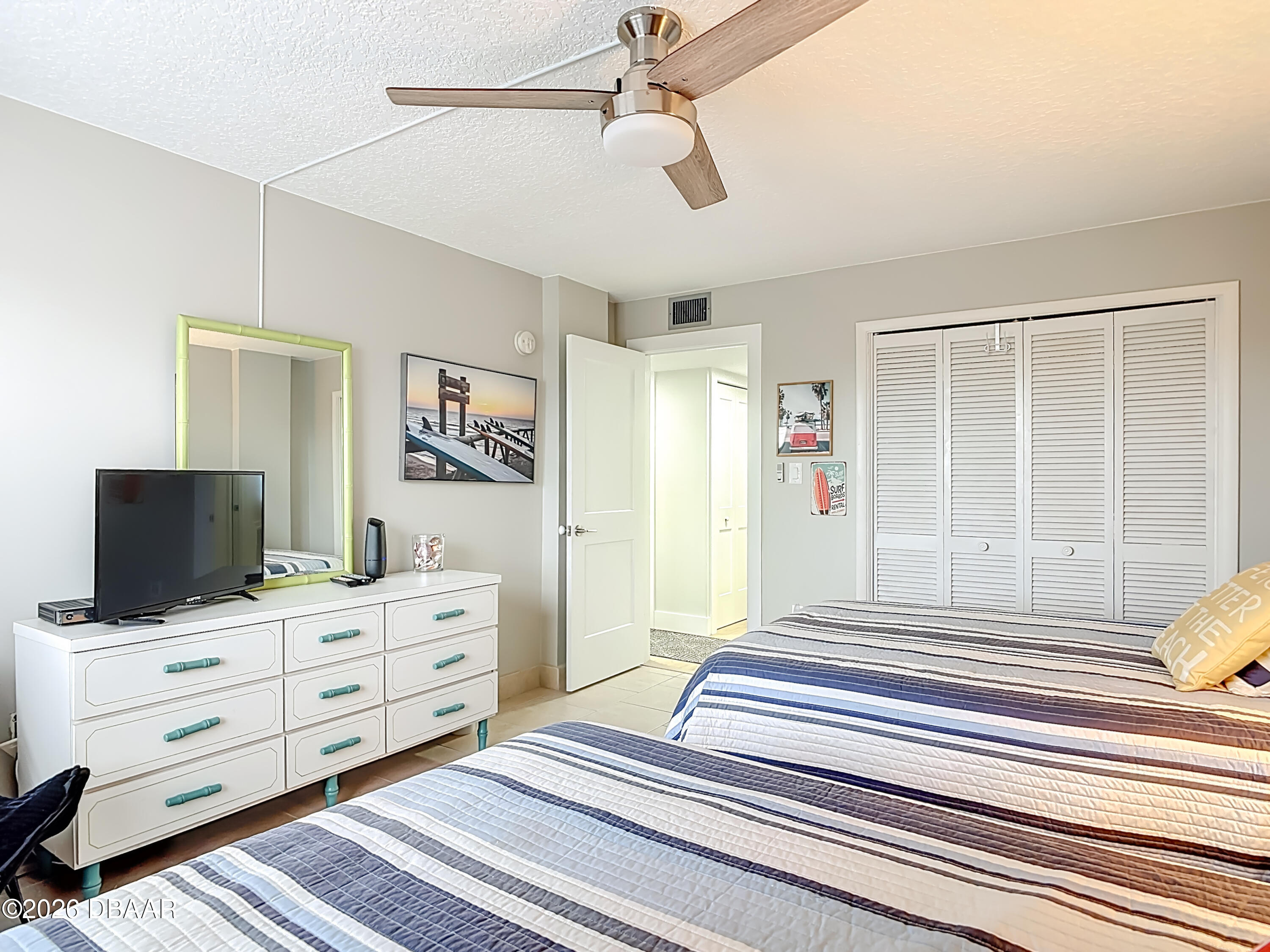 4445 South Atlantic Avenue, Unit 301 Ponce Inlet, FL 32127 - Photo 24 of 45 a bedroom with furniture and flat screen tv