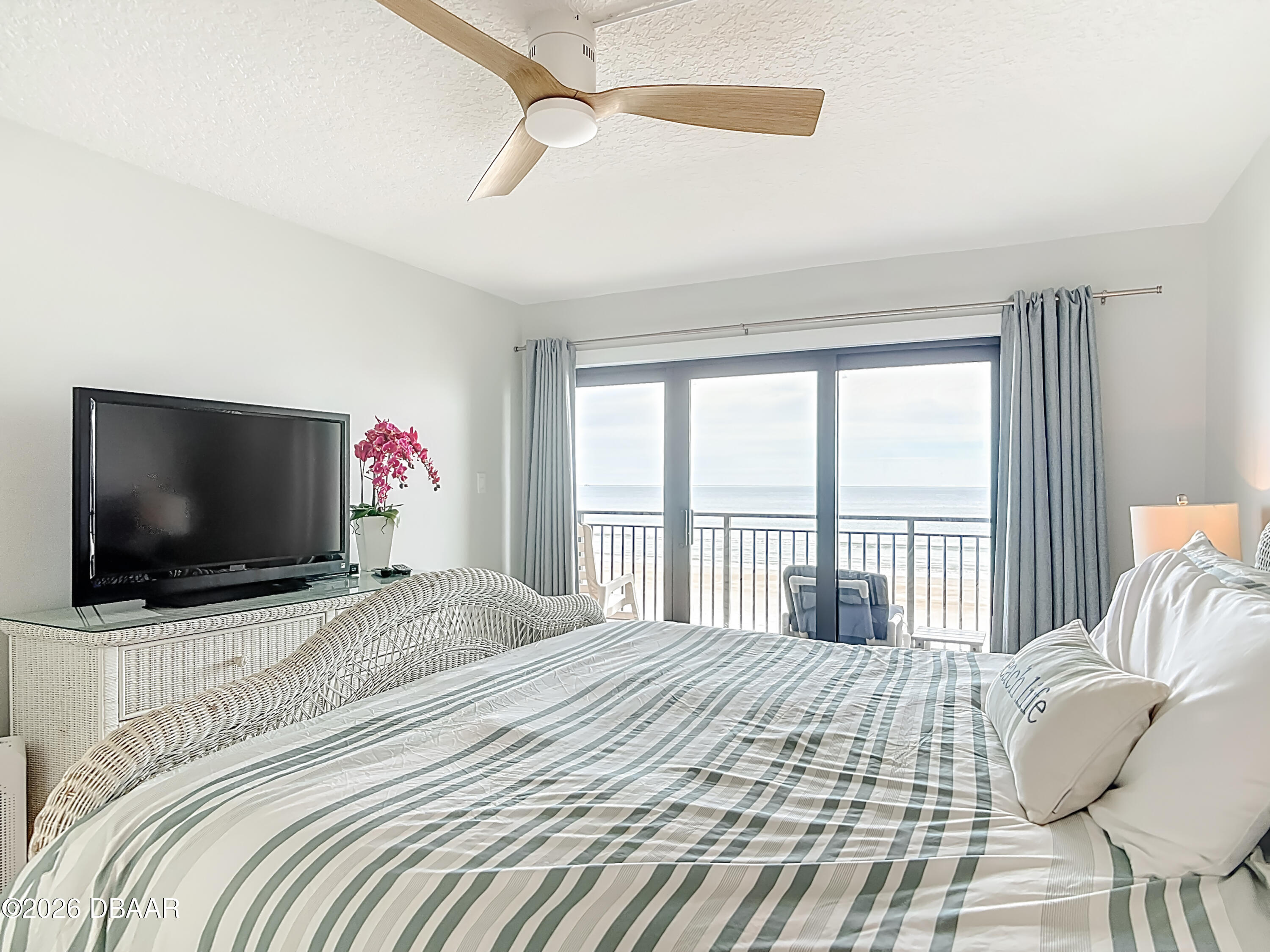 4445 South Atlantic Avenue, Unit 301 Ponce Inlet, FL 32127 - Photo 26 of 45 a bedroom with a bed and a flat screen tv