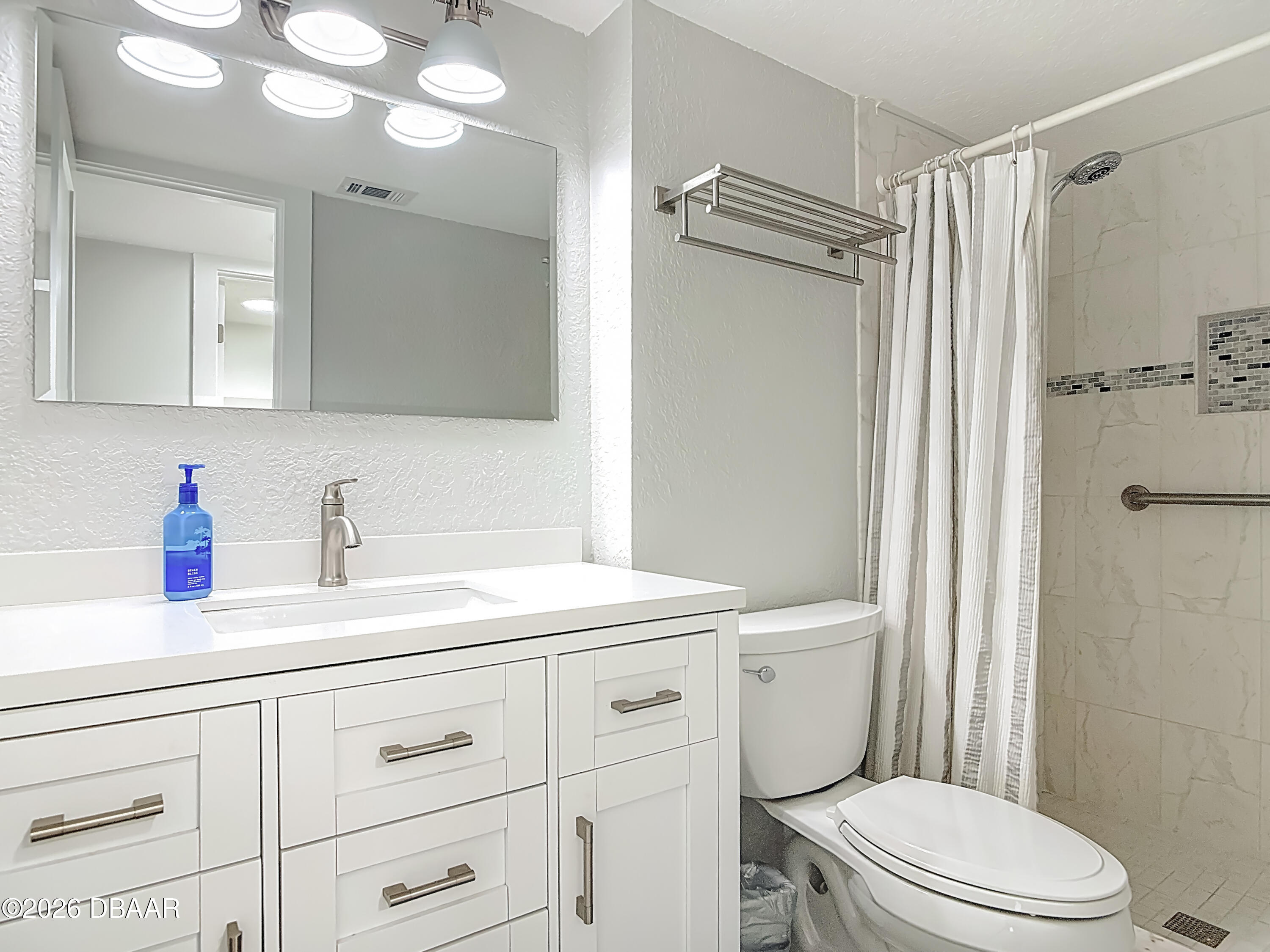 4445 South Atlantic Avenue, Unit 301 Ponce Inlet, FL 32127 - Photo 29 of 45 a bathroom with a sink a toilet a mirror and shower
