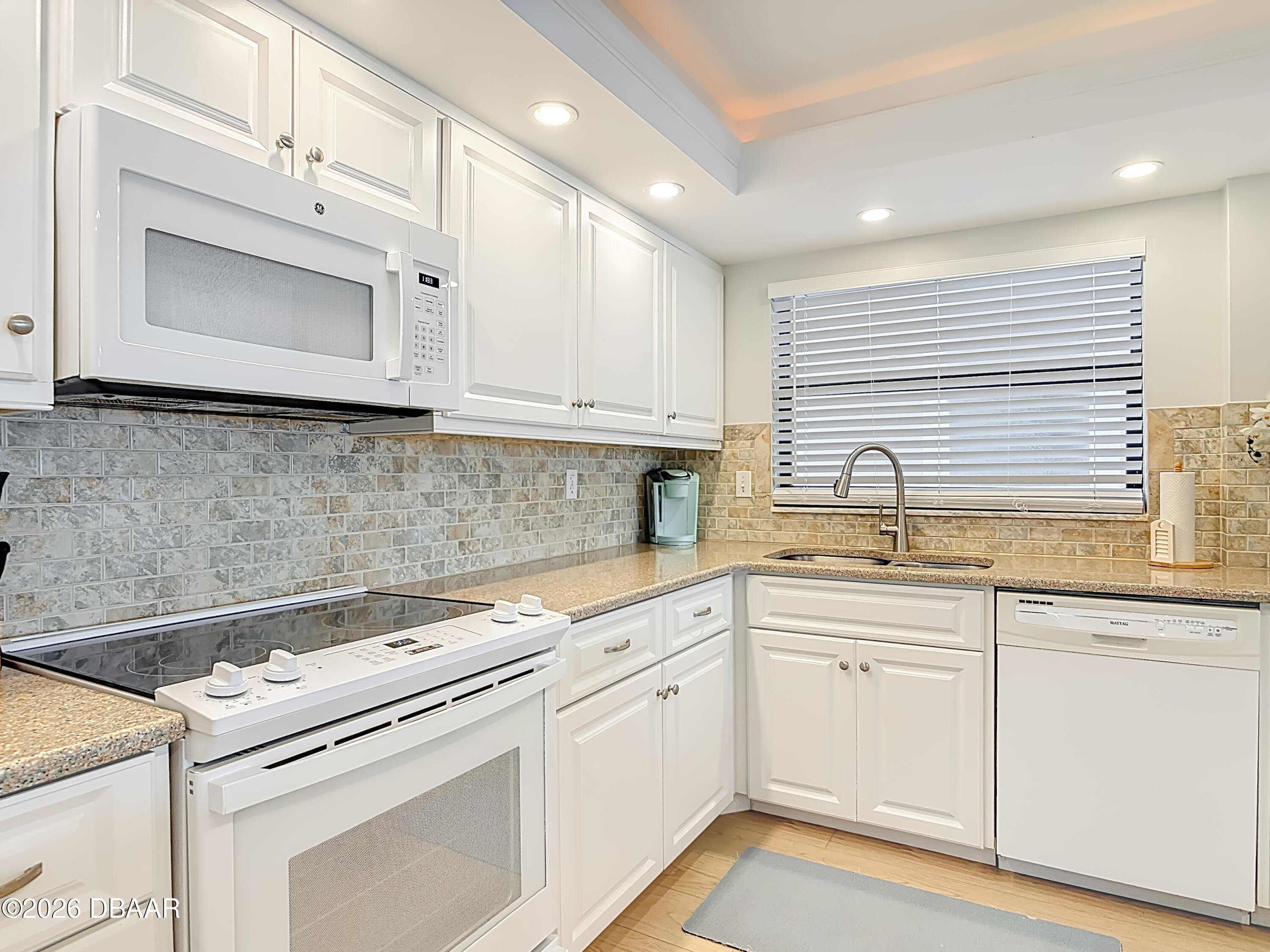 4445 South Atlantic Avenue, Unit 301 Ponce Inlet, FL 32127 - Photo 6 of 45 a kitchen with white cabinets appliances and a sink