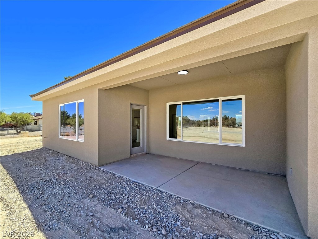 1120 West Gamebird Road Pahrump, NV 89048 - Photo 8 of 36 Rear view of house featuring a patio and stucco siding