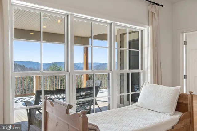 a view of a kitchen with kitchen island a sink wooden floor and a view of living room