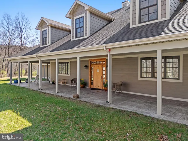 a living room with couches and kitchen view with wooden floor