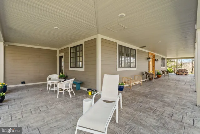 a kitchen with granite countertop a stove a sink and white cabinets with wooden floor