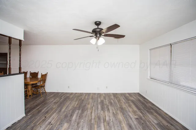 a view of room with wooden floor a ceiling fan and a window