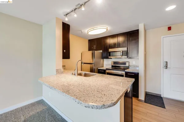 a kitchen with a sink a counter top space stainless steel appliances and cabinets