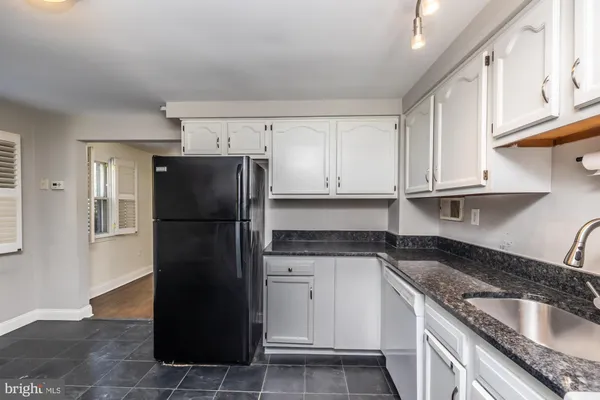 a kitchen with a sink a refrigerator and cabinets