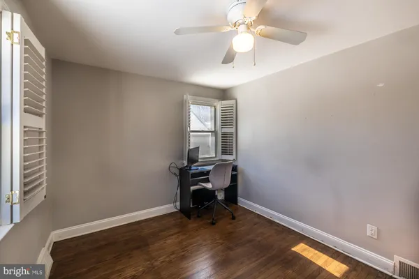 an empty room with a window and wooden floor