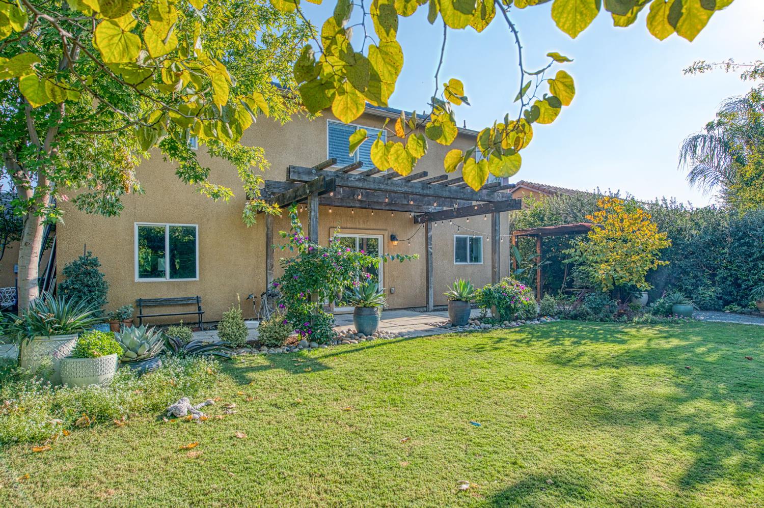 5855 East Platt Avenue Fresno, CA 93727 - Photo 12 of 57 a front view of a house with a big yard and potted plants
