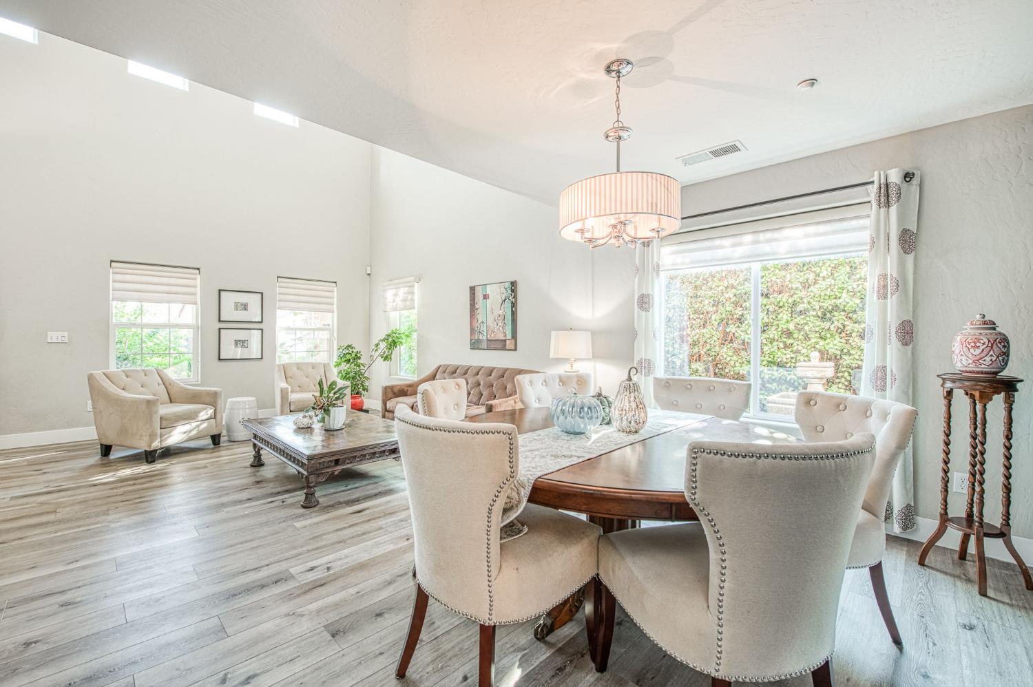 5855 East Platt Avenue Fresno, CA 93727 - Photo 23 of 57 a dining room with wooden floor a chandelier a glass table and chairs
