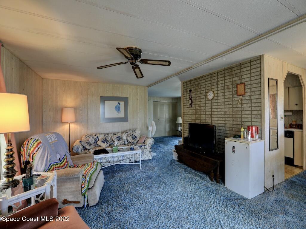 939 Laurel Circle Barefoot Bay, FL 32976 - Photo 11 of 36 a living room with furniture and a fireplace