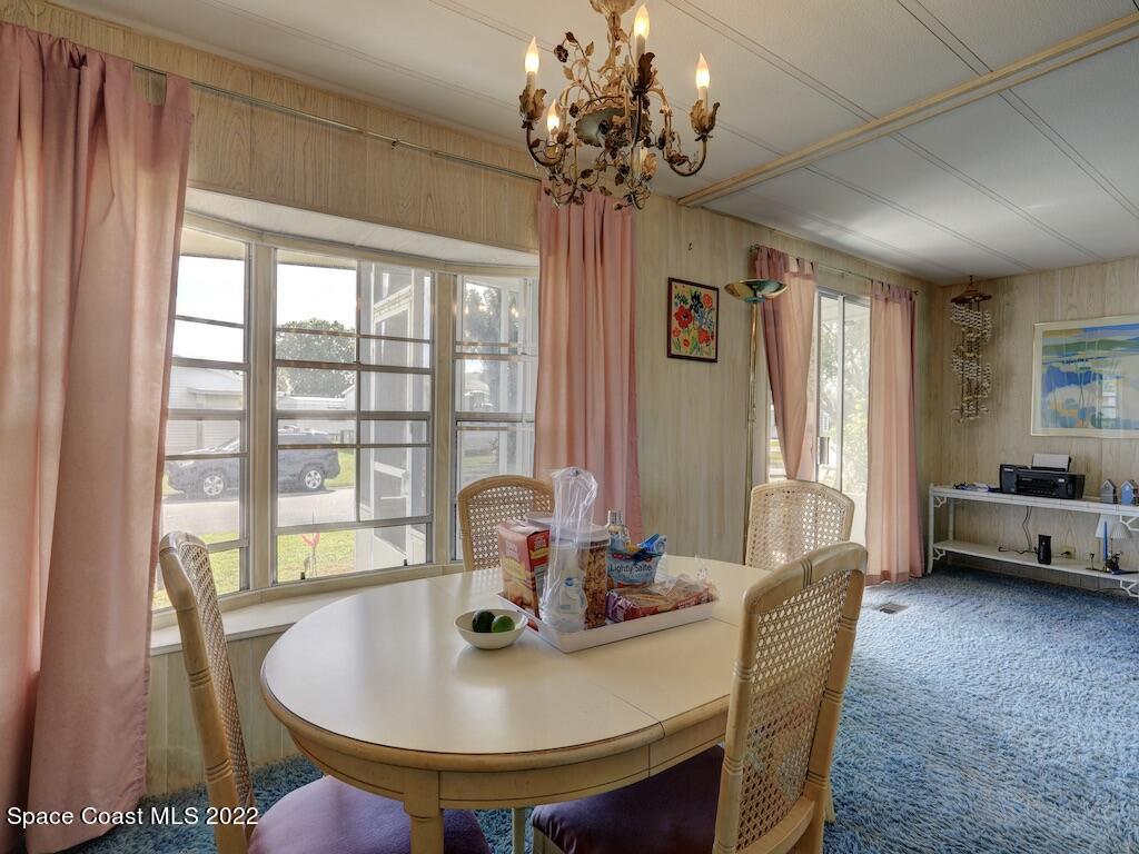 939 Laurel Circle Barefoot Bay, FL 32976 - Photo 14 of 36 a view of a dining room with furniture wooden floor and chandelier