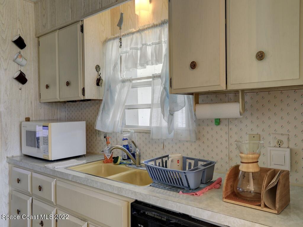 939 Laurel Circle Barefoot Bay, FL 32976 - Photo 19 of 36 a kitchen with granite countertop a sink a stove and cabinets