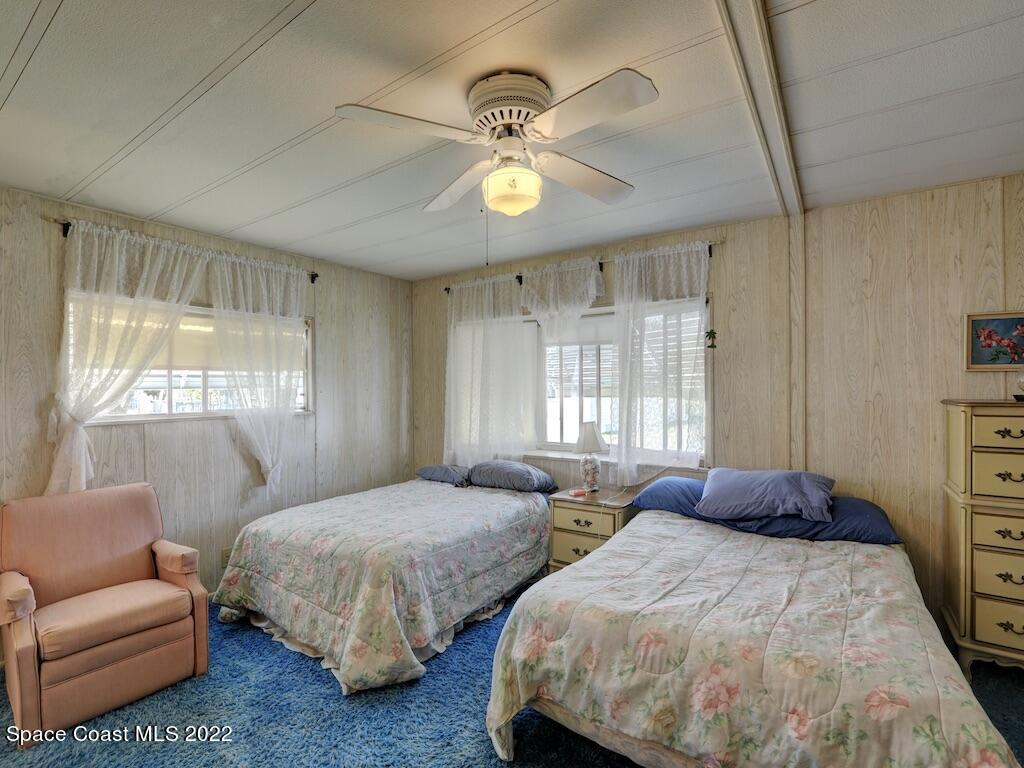 939 Laurel Circle Barefoot Bay, FL 32976 - Photo 21 of 36 a bedroom with two beds and a large window