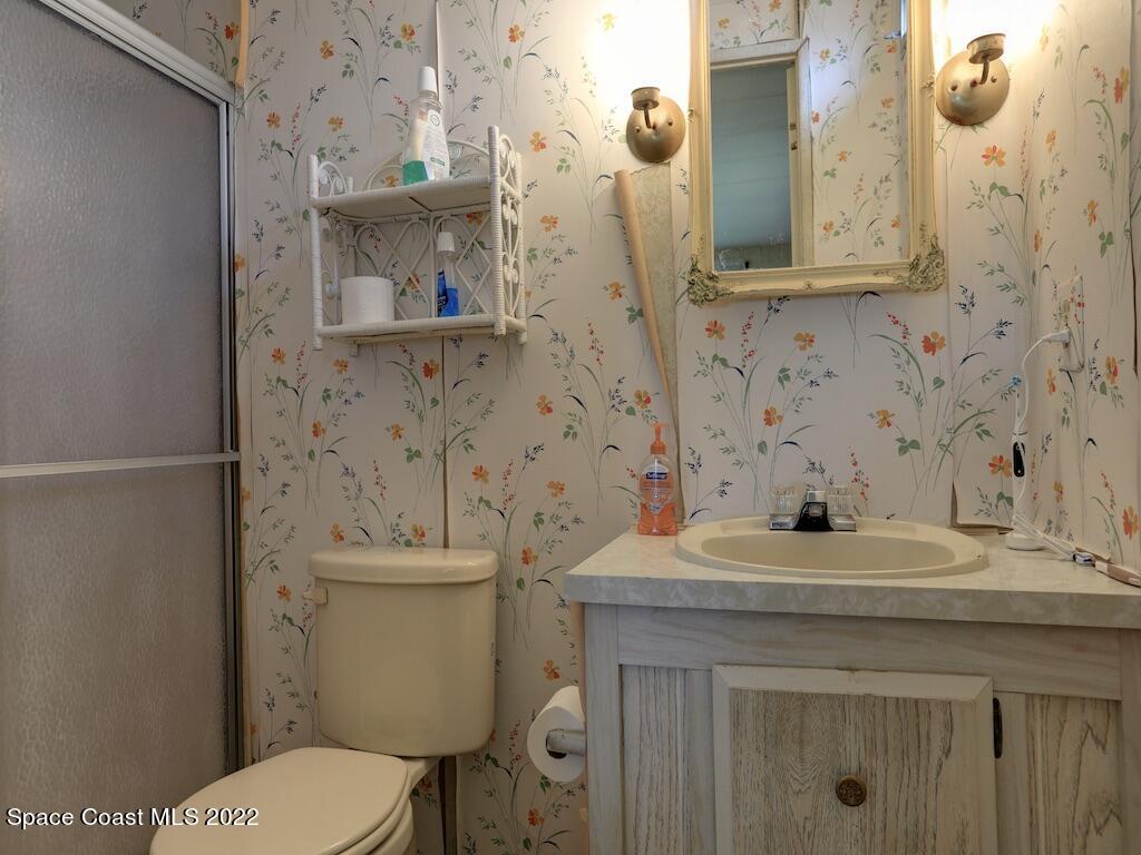 939 Laurel Circle Barefoot Bay, FL 32976 - Photo 24 of 36 a bathroom with a sink a toilet and mirror