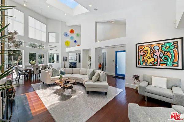 a living room with furniture kitchen view and a large window