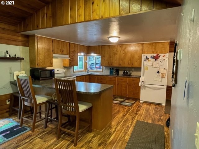 40553 Little Fall Creek Road Fall Creek, OR 97438 - Photo 14 of 28 a kitchen with stainless steel appliances granite countertop a sink a stove a refrigerator a dining table and chairs with wooden floor