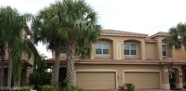 a view of a white house with a tree