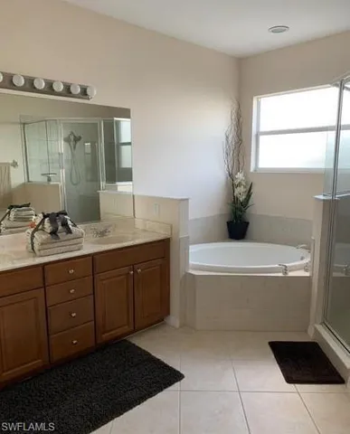 a spacious bathroom with a tub sink and mirror
