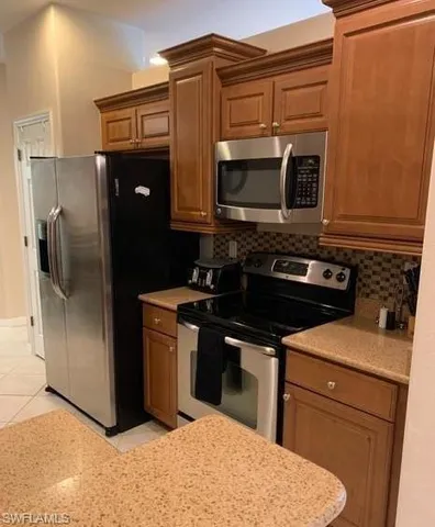 a kitchen with stainless steel appliances granite countertop a stove a microwave and a refrigerator