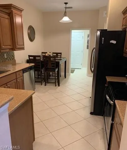 a kitchen with granite countertop a refrigerator a stove and a dining table