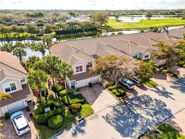 an aerial view of ocean and residential houses with outdoor space