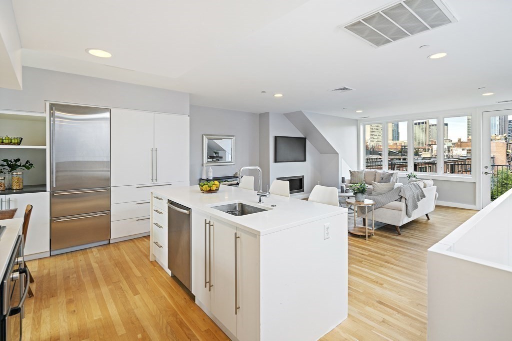 663 Tremont Street, Unit 3 Boston, MA 02118 - Photo 1 of 33 a kitchen that has a lot of cabinets a sink and a refrigerator in it