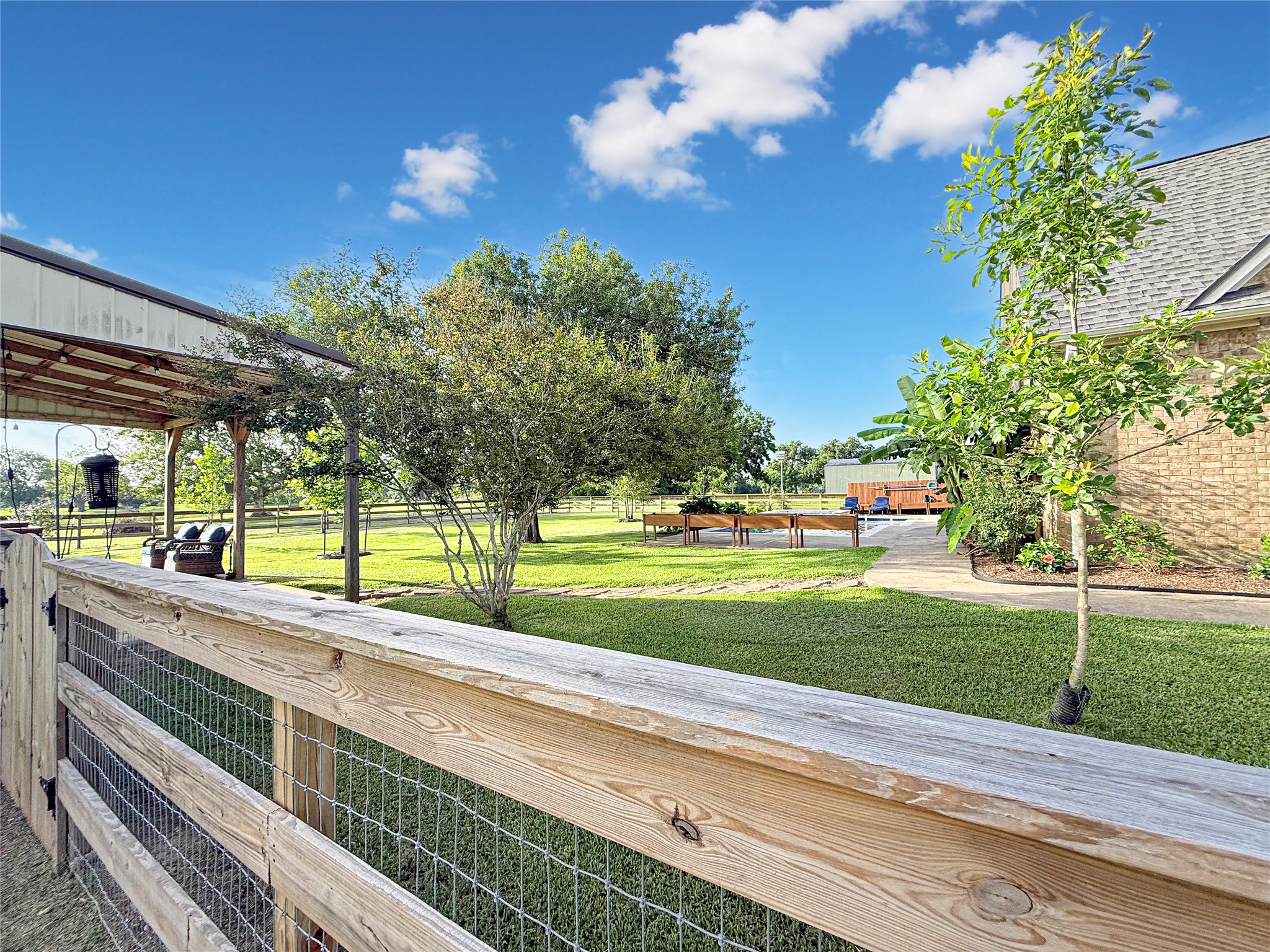 807 Mill Road Angleton, TX 77515 - Photo 37 of 46 Three-rail fenced backyard surrounds the pool, creating a private outdoor retreat.