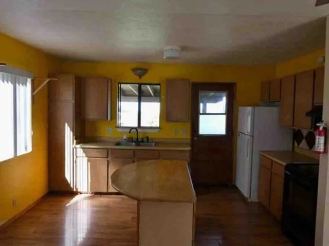 a kitchen with refrigerator cabinets and wooden floor
