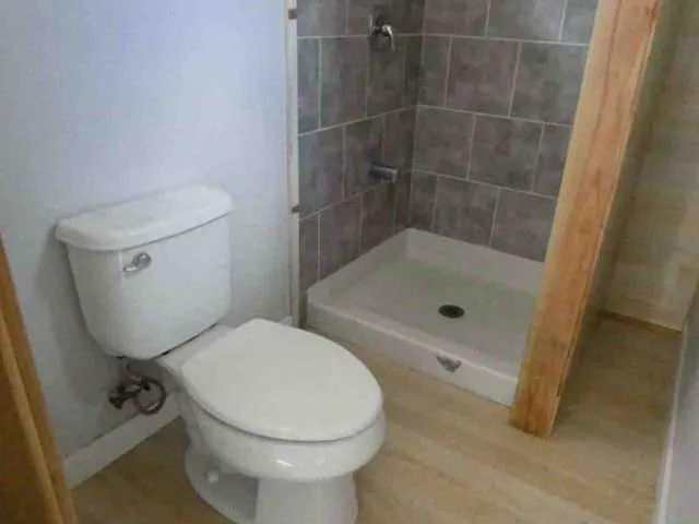 a bathroom with a toilet and a shower