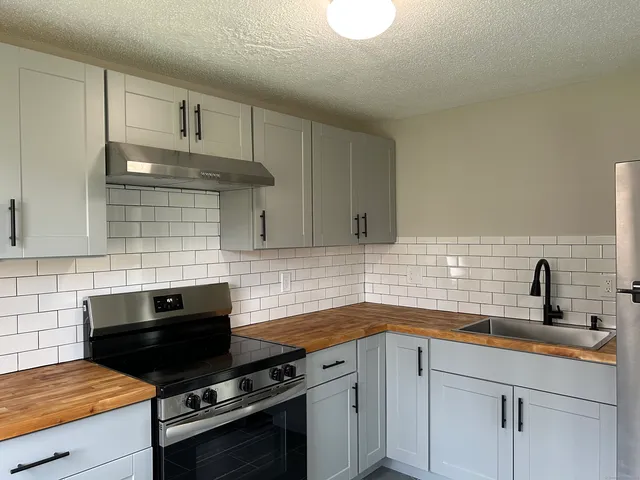 a kitchen with a sink stove and cabinets