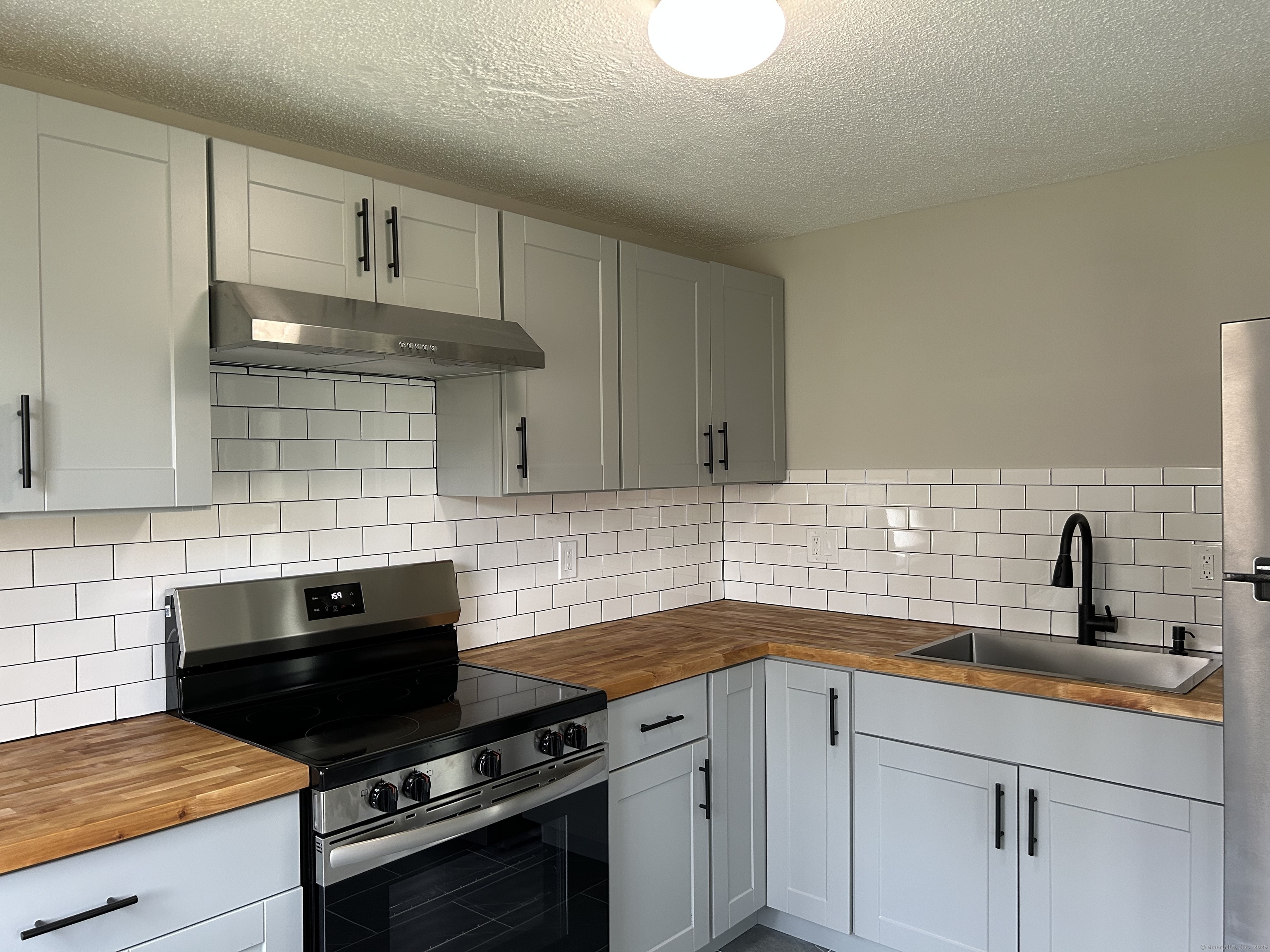 7 Padanaram Road, Unit J253 Danbury, CT 06811 - Photo 3 of 12 a kitchen with a sink stove and cabinets