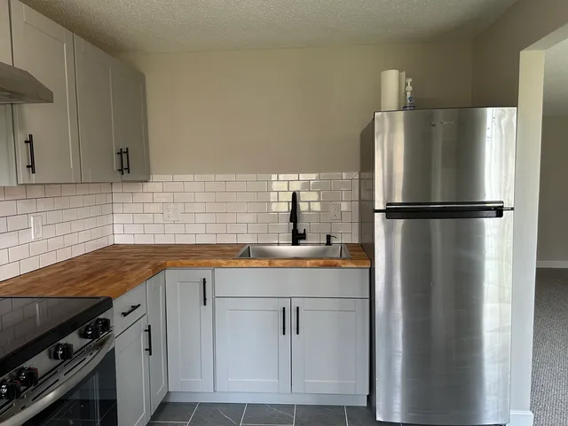 a kitchen with stainless steel appliances a refrigerator sink and cabinets