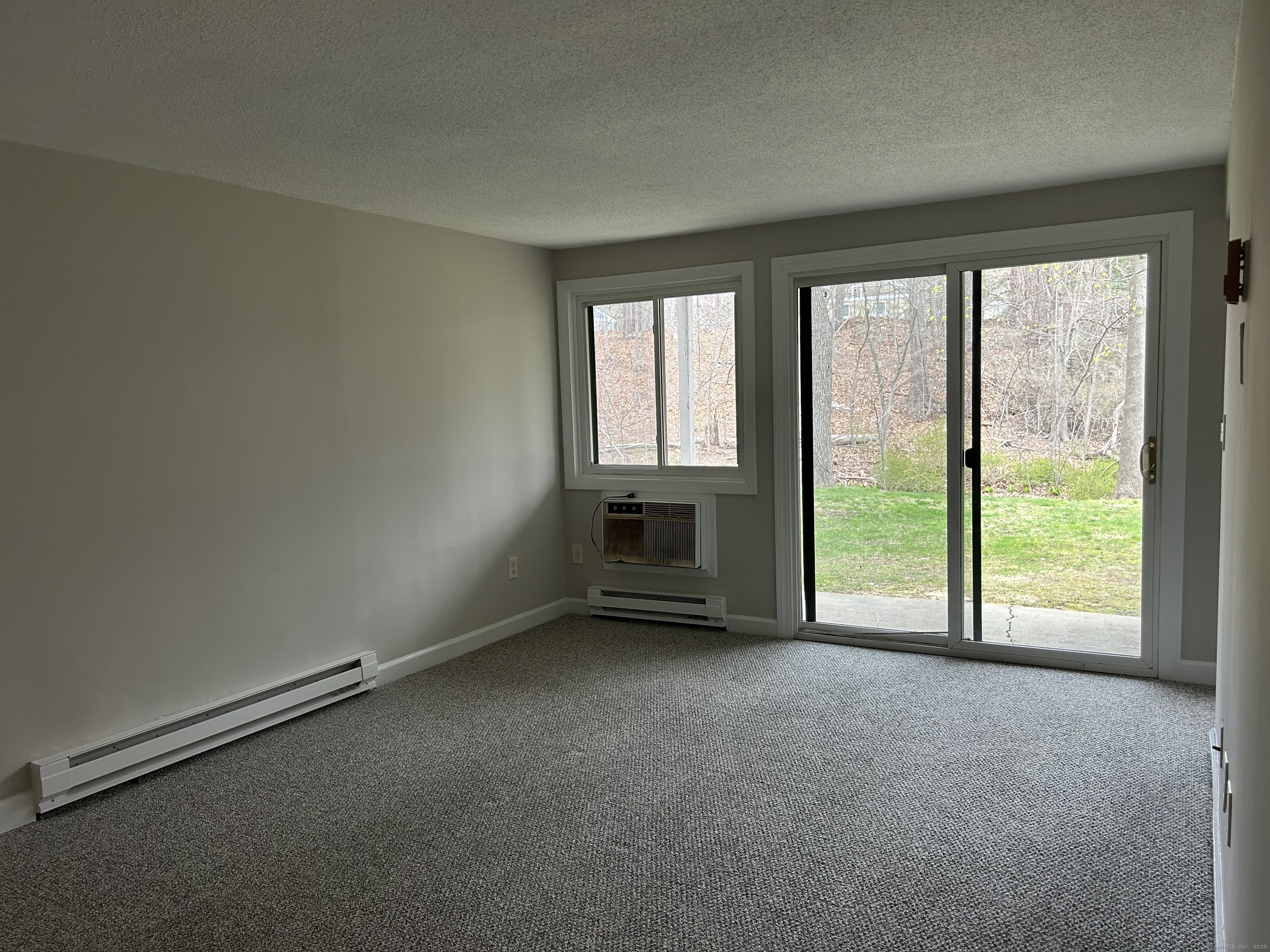 7 Padanaram Road, Unit J253 Danbury, CT 06811 - Photo 5 of 12 an empty room with a fireplace and a floor to ceiling window