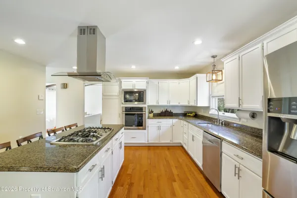 a kitchen with granite countertop a sink a counter top space and cabinets