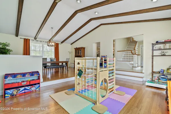 a kitchen with stainless steel appliances kitchen island granite countertop a refrigerator a stove a sink dishwasher and white cabinets with wooden floor