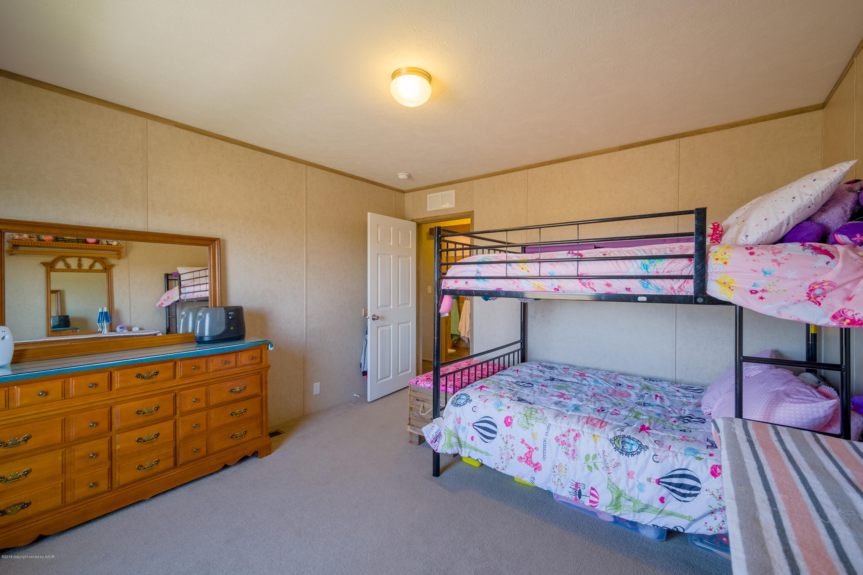 22300 Adkisson Road Canyon, TX 79015 - Photo 21 of 37 a bedroom with a bed and a dresser in it