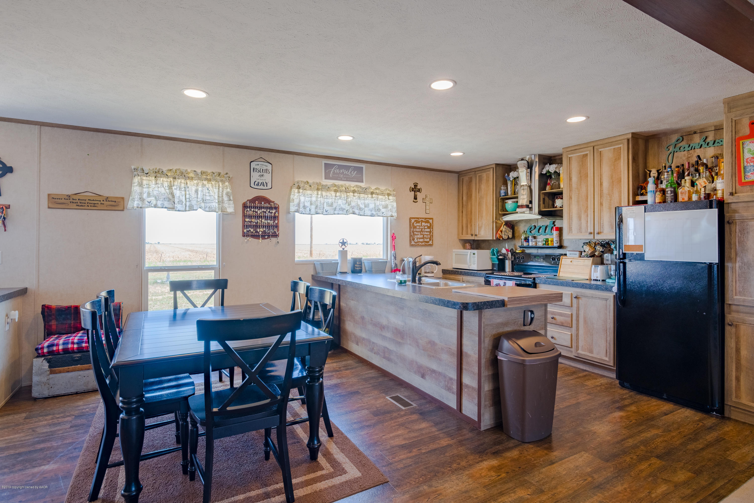22300 Adkisson Road Canyon, TX 79015 - Photo 10 of 37 a kitchen with sink a refrigerator and chairs