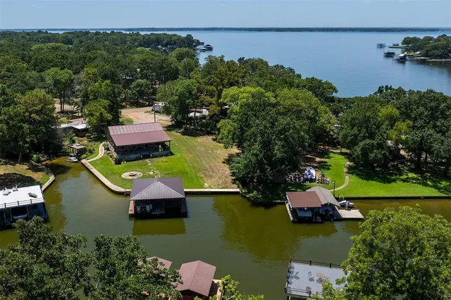 an aerial view of residential houses with outdoor space and lake view