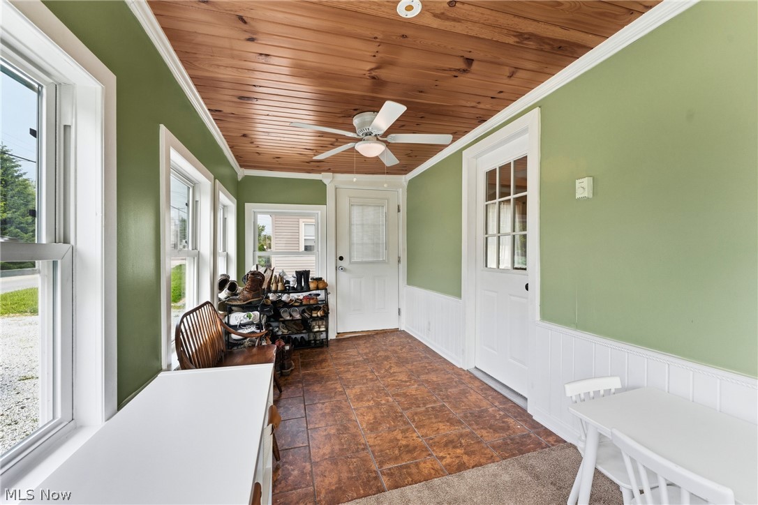 258 Randolph Road Mogadore, OH 44260 - Photo 7 of 49 Enclosed porch featuring a wood-plank ceiling, ceiling fan, multiple windows, tiled flooring, and a white paneled door with glass inserts