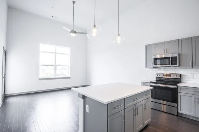 a kitchen with stainless steel appliances granite countertop a sink a stove a microwave and wooden floors